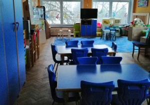 Sala przedszkolna. Niebieskie meble, firanki, dywan.Sufit ozdobiony kolorowymi pomponami z tiulu