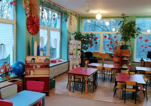 Sala przedszkolna. Czerwone stoliki dziecięce, zabawki
