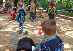 Dzieci bawią się w piaskownicy.