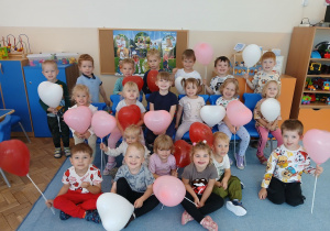 Dzieci z grupy Motylków pozują do zdjęcia z balonami.