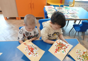 Chłopcy wykonują prace plastyczną.