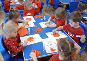 Motylki wykonują prace plastyczne, smaczne, czerwone jabłuszka..