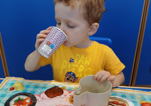 Chłopiec pije świeżo wyciśnięty sok.