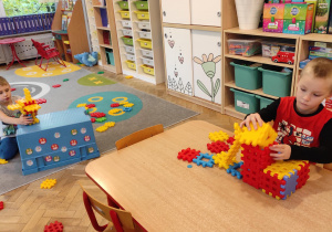 Chłopcy konstruują budowle z klocków.