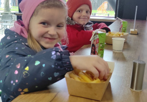 Najlepszy punkt wycieczki. Dzieci jedzą frytki w gastronomi na terenie łódzkiego zoo.