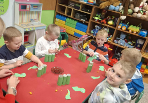 Dzieci tworzą dinozaury z papieru.