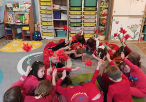 Dzieci wykonują ćwiczenia z kwiatami.