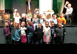 Dzieci pozują na tle wielkiej sceny teatru Piccolo.