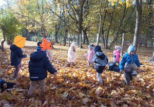 Dzieci świetnie się bawią wśród liści.