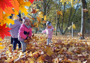 Dziewczynki obrzucają się liśćmi.