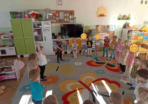 Dzieci, ustawione w kółeczku, śpiewają Neli - Sto Lat!