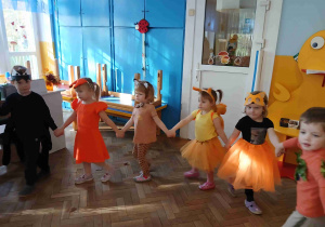 Dzieci tańczą w kółeczku.