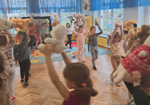 Dzieci tańczą wraz ze swoimi misiami.