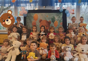 Żabki pozują całą grupą do zdjęcia na balu pluszowego misia.